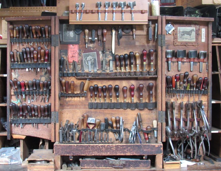 Standing in the Bowman Harness workshop is an intriguing antique cabinet whose open doors reveal rows of vintage hand punches, most of which belonged to Joe Bowman Jr.’s grandfather.