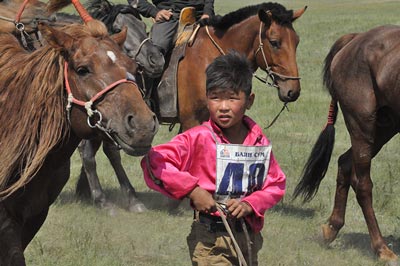 A young jockey cools off his horse after a 28km Naadam race that just happened to be running as the Gobi Gallop passed by.
