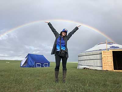 Heather Wallace celebrates a double rainbow in front of the ger she shared with the other female Officials in Mongolia, The Land of the Eternal Blue Sky. © Gobi Desert Cup