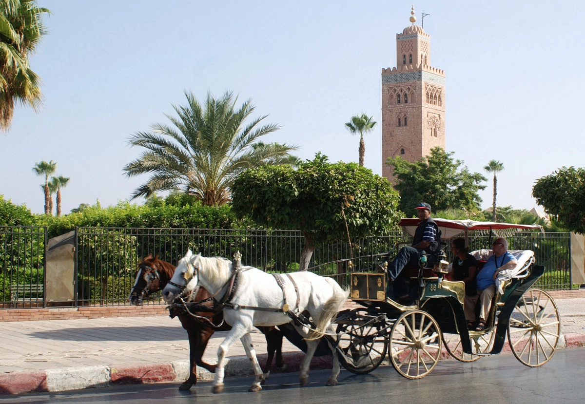 Tourists ride a horse-drawn carriage near the Koutoubia minaret and Jamaa el-Fna Square during a tour of Marrakesh (Photo: Getty)