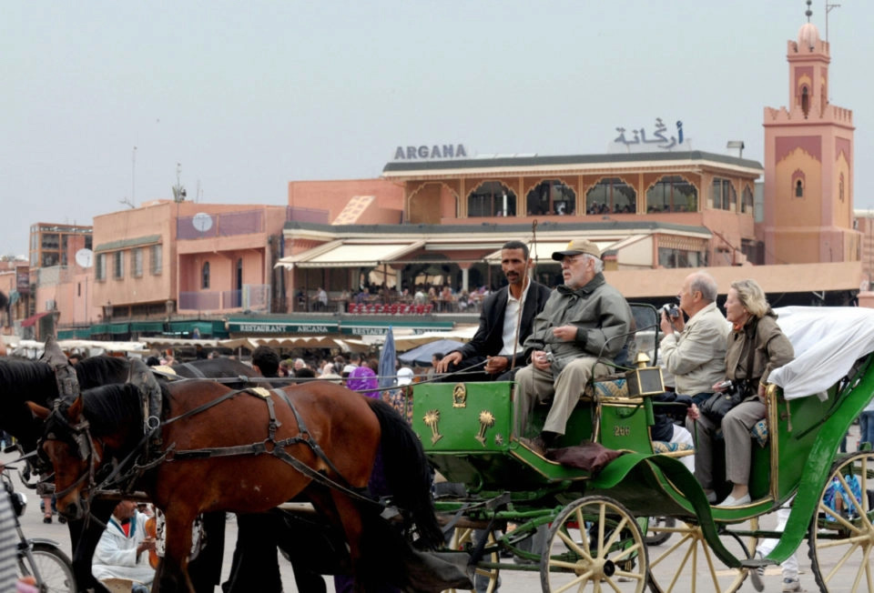 Tourists sit in a horse-drawn carriage next to the mosque Koutoubia in the touristic city of Marrakech (Photo: Getty)