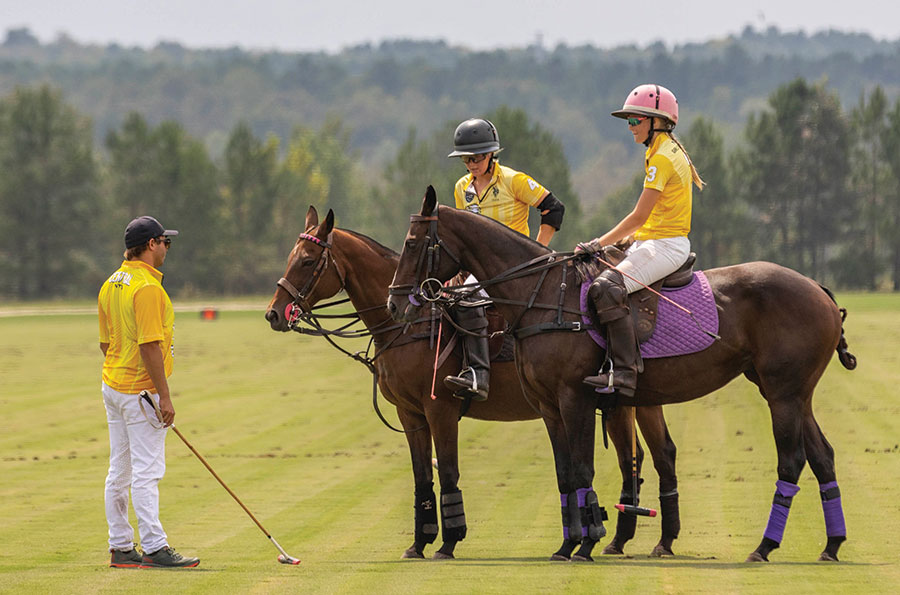 Summer Kneece and Lauren Patoile get coaching from professional Santi Torres. Photo courtesy of the US Polo Association